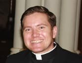 Fr. Jan Kusyk, Director of Vocations for the Archdiocese of Kingston, smiling, in a clerical collar.
