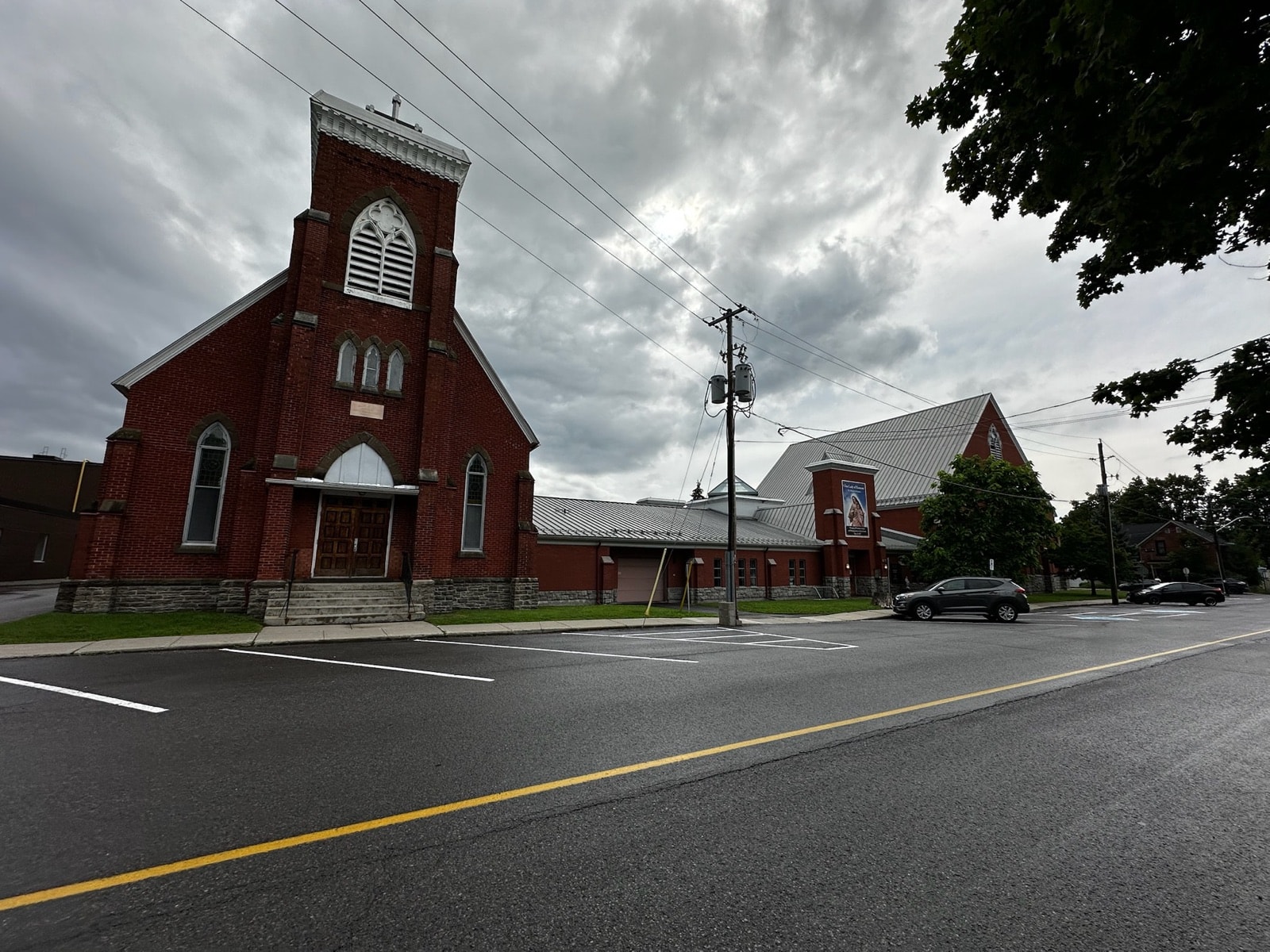 Street view of St. Mary's: the original red-brick church with its bell tower on the left, joined to the larger church built in 1994 on the right.