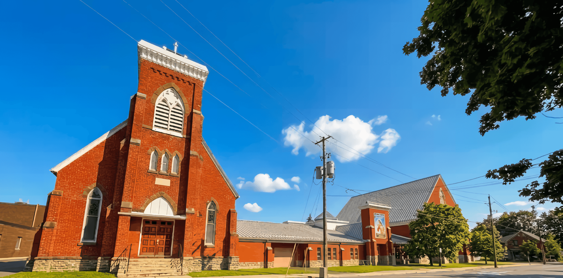 St. Mary's seen from the street: the 1884 red-brick church with its Gothic bell tower and arched louvred belfry window, joined to the larger church built in 1994 alongside it.